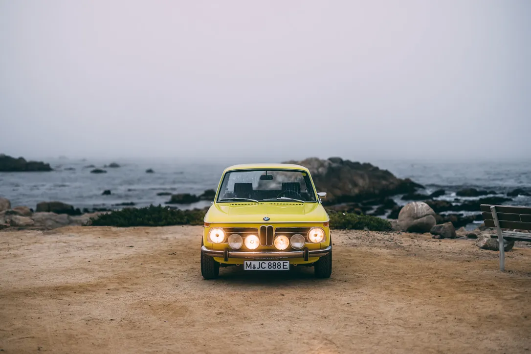 Ein gelber BMW 2002 von Bavarian Econs am Meer
