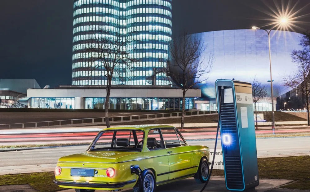 Ein elektrischer BMW 2002 lädt vor dem BMW-Turm in München