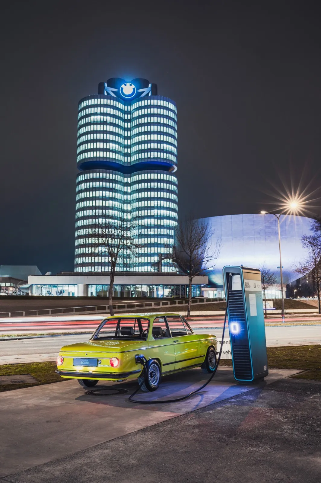 Ein elektrischer BMW 2002 lädt vor dem BMW-Turm in München