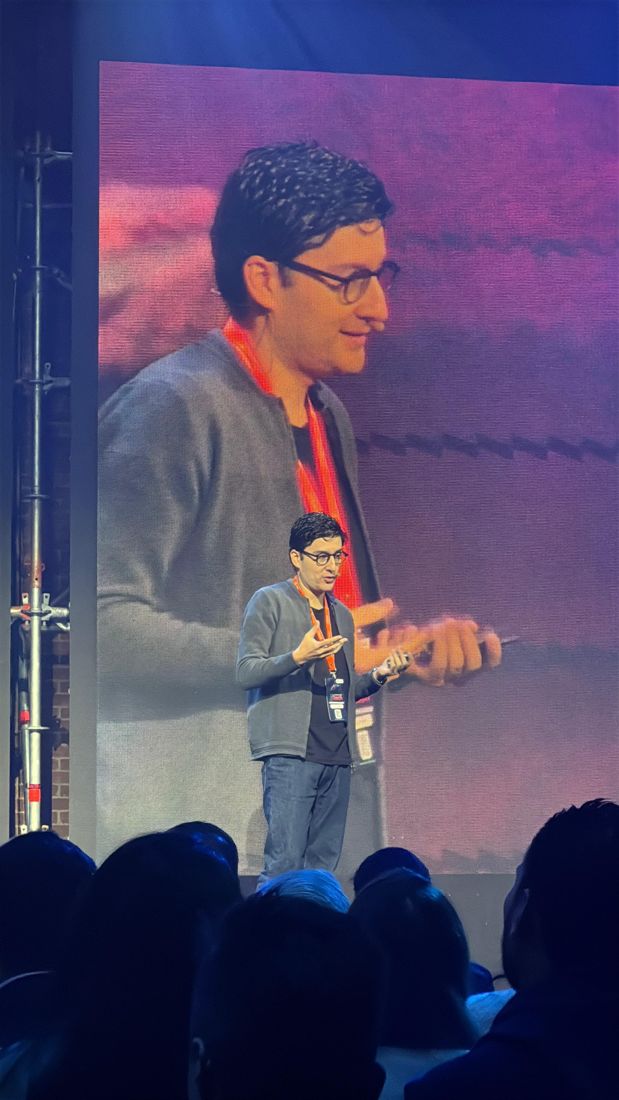Edgar giving a talk, with his image on the screen behind
